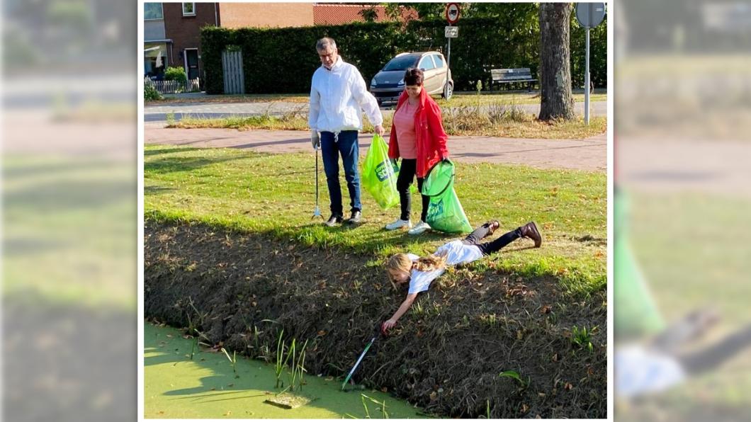 Foto van meisje die afval uit sloot haalt tijdens World Cleanup Day 2020